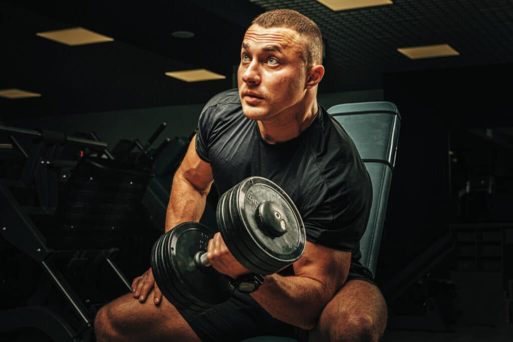 Testépítő férfi bicepsz gyakorlat közben, Anavar erőnlét támogatással
