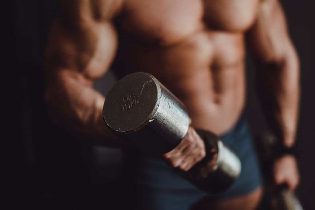 Legjobb oxandrolone – közelkép egy súlyzót tartó izmos karról, testépítés közben